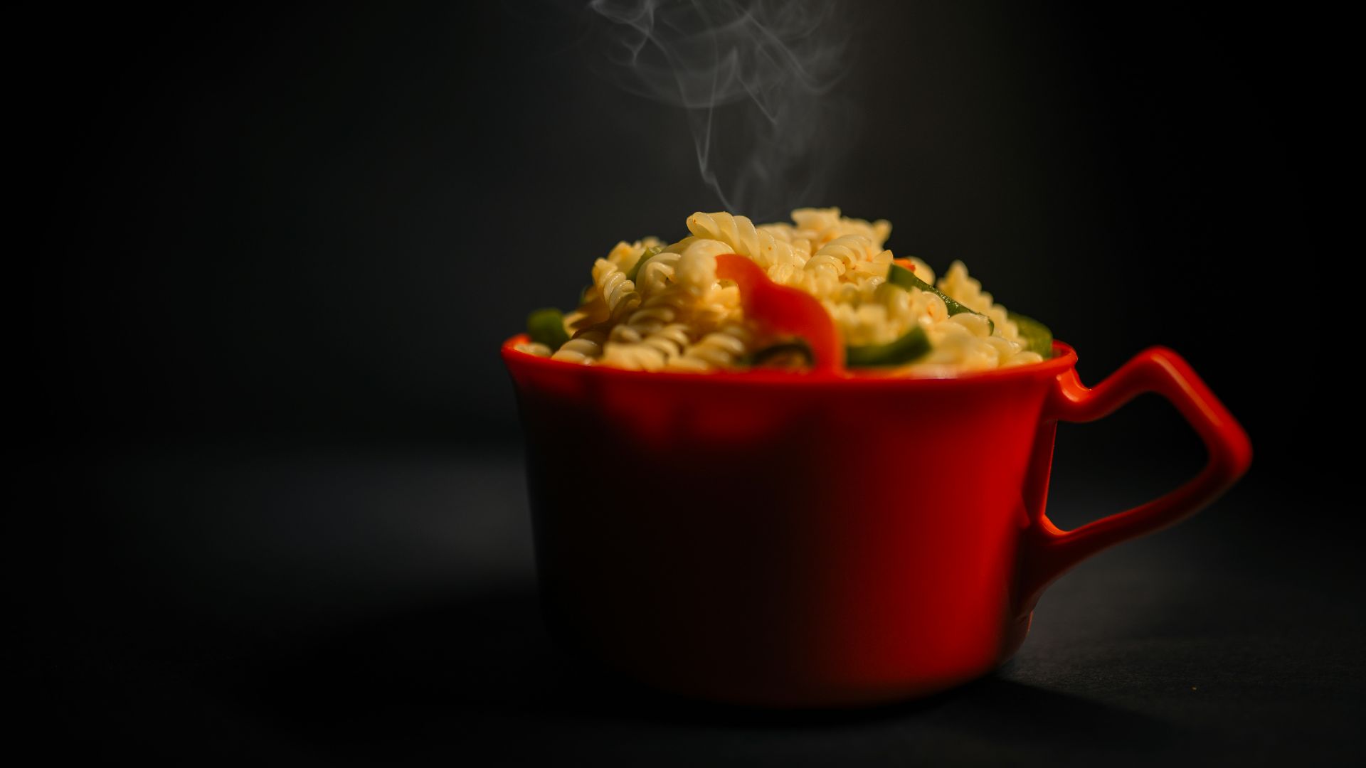 a red bowl of food with steam rising out of it