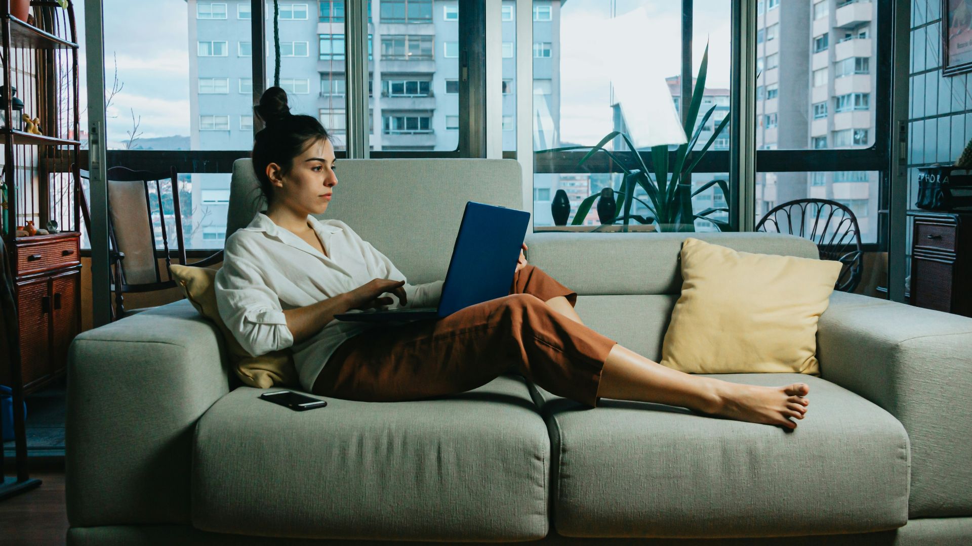 woman in white long sleeve shirt sitting on white couch