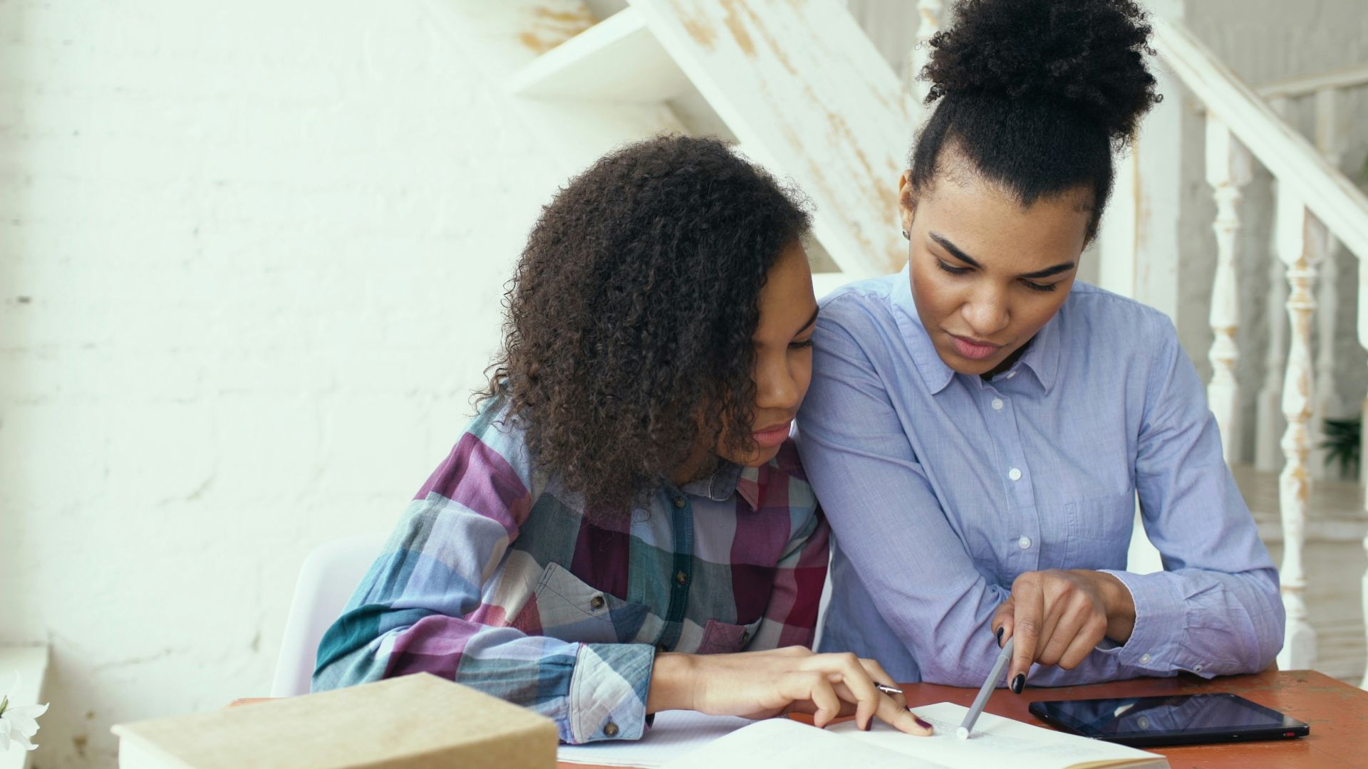 Mother and daughter studying together at a table.