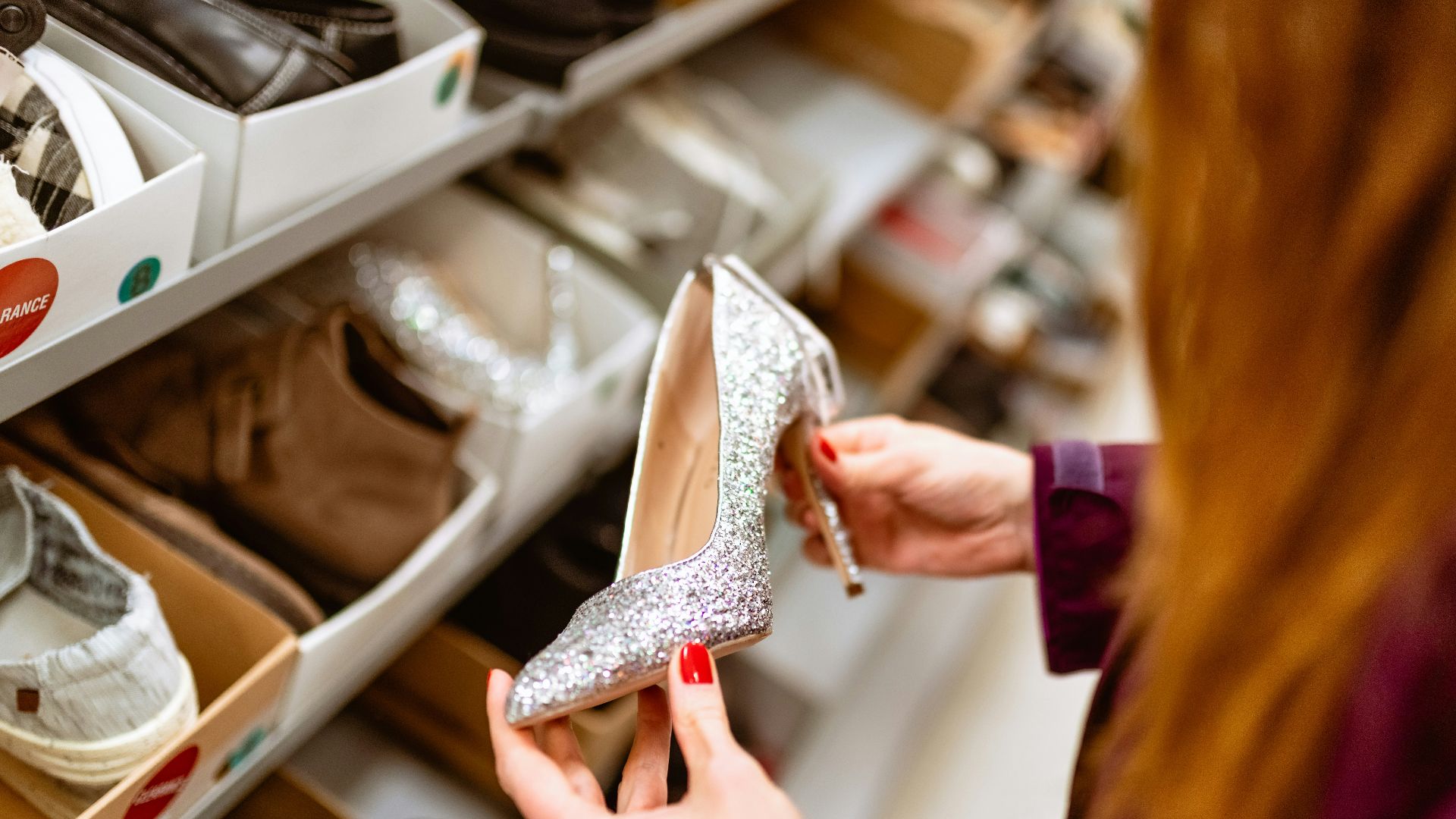 a woman looking at a pair of shoes in a shoe store