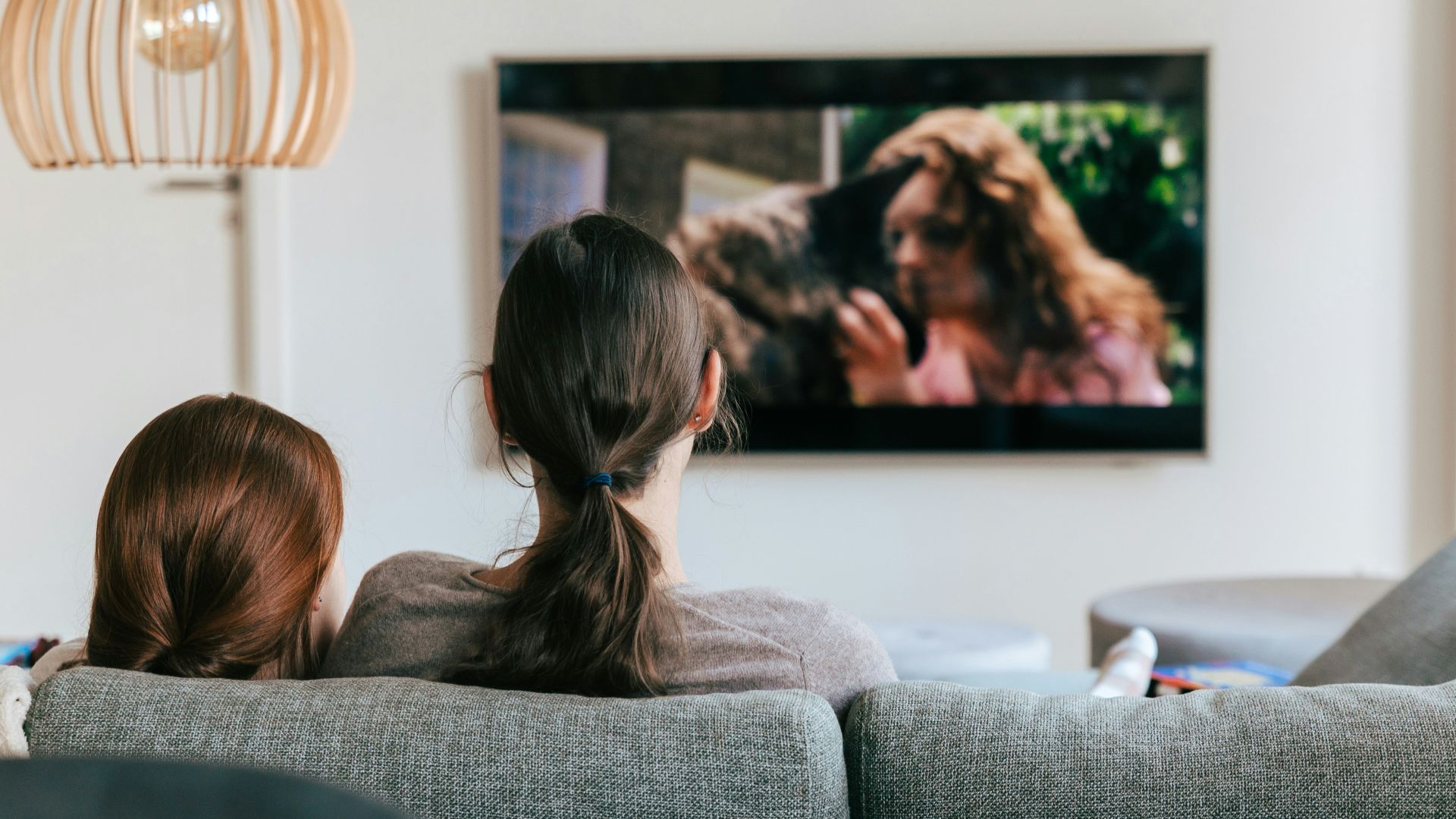 a couple of women sitting on top of a couch