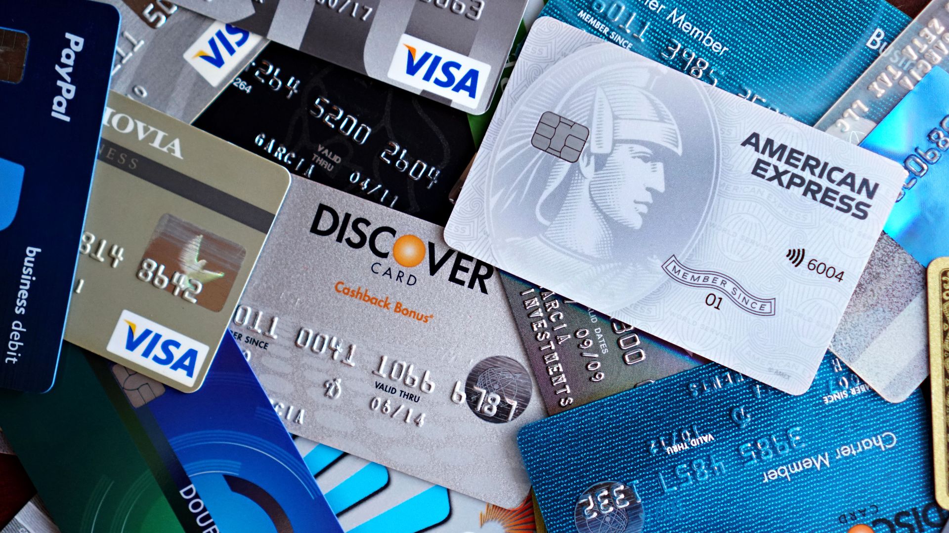 Close-up image of various credit cards including Visa, Mastercard, and American Express.