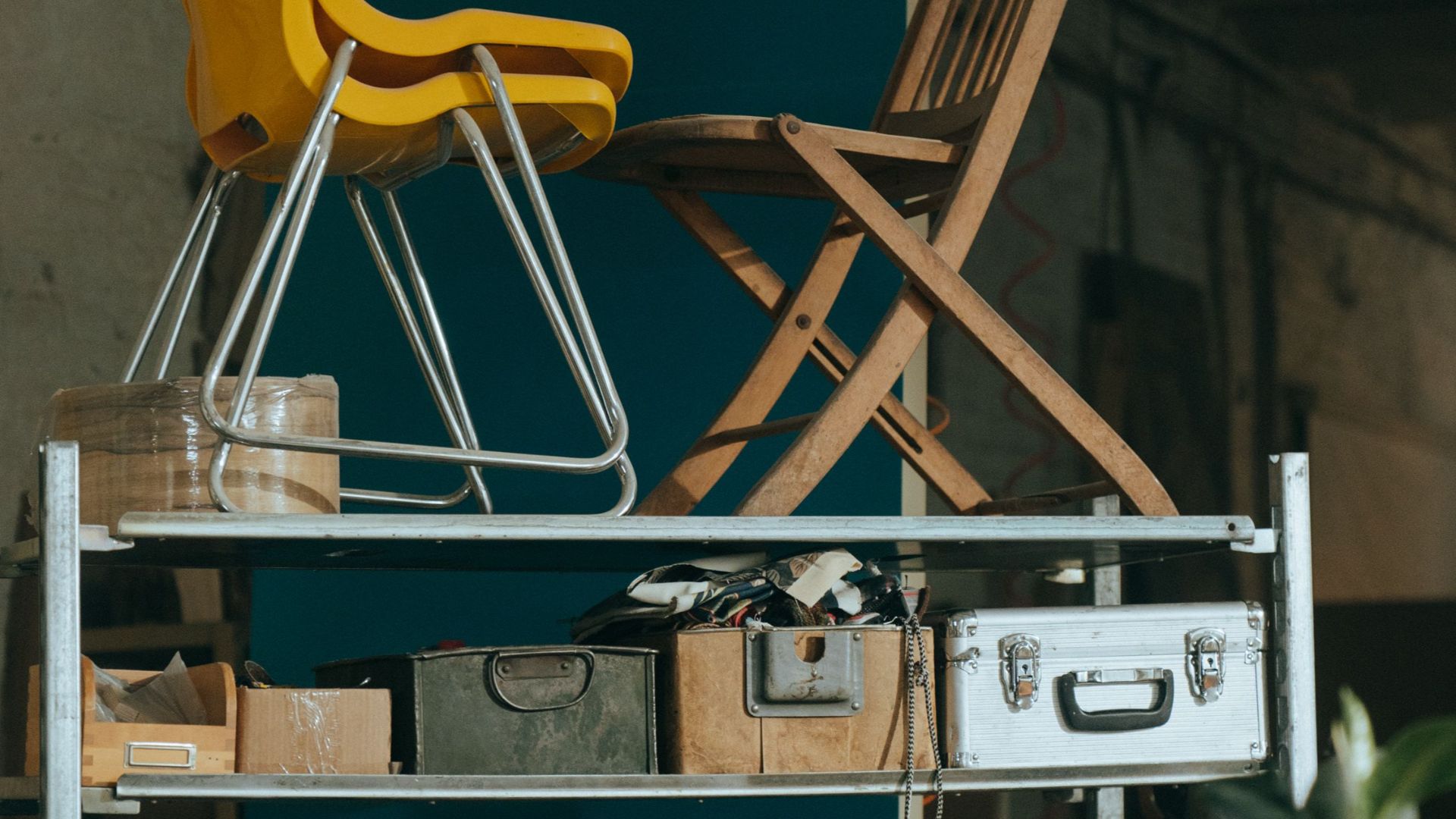 Interior view of a shelf with vintage furniture pieces and storage items.