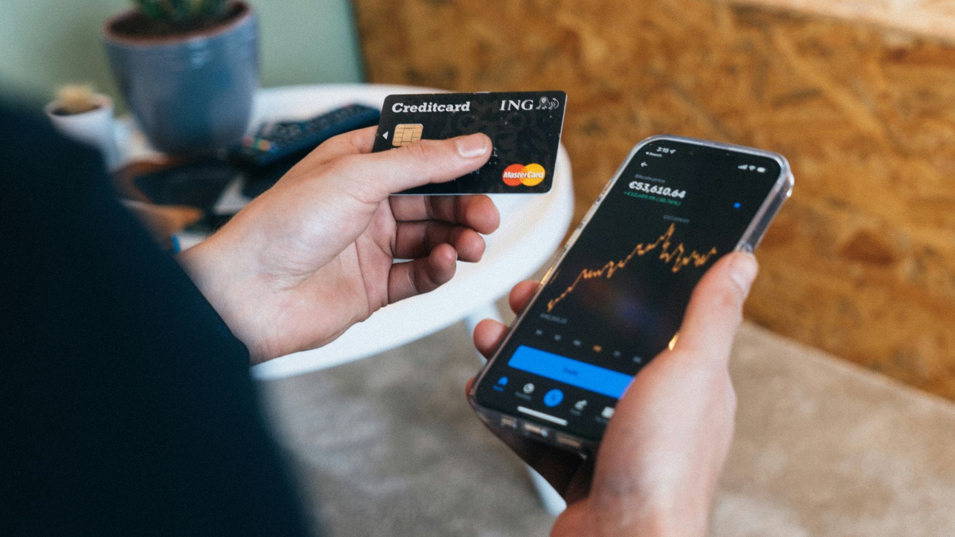 a person holding a smart phone and a credit card