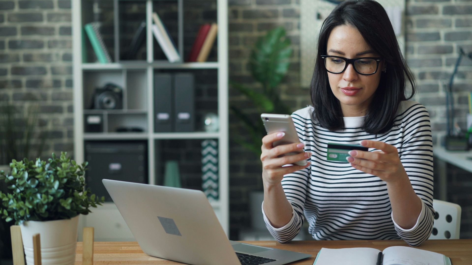 a woman sitting at a table looking at her cell phone