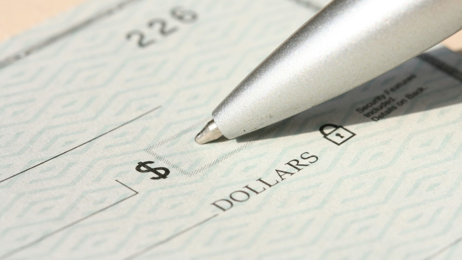 Pen poised over a check, ready to write.
