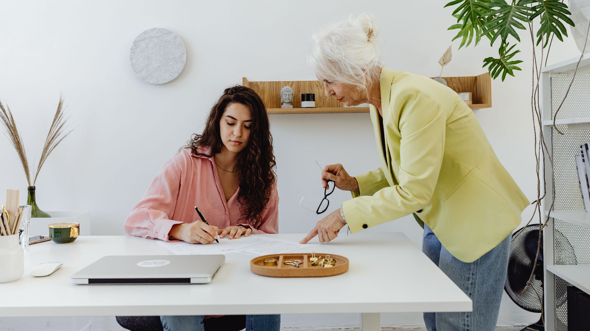 Two women collaborating in a modern office, highlighting teamwork and diversity.