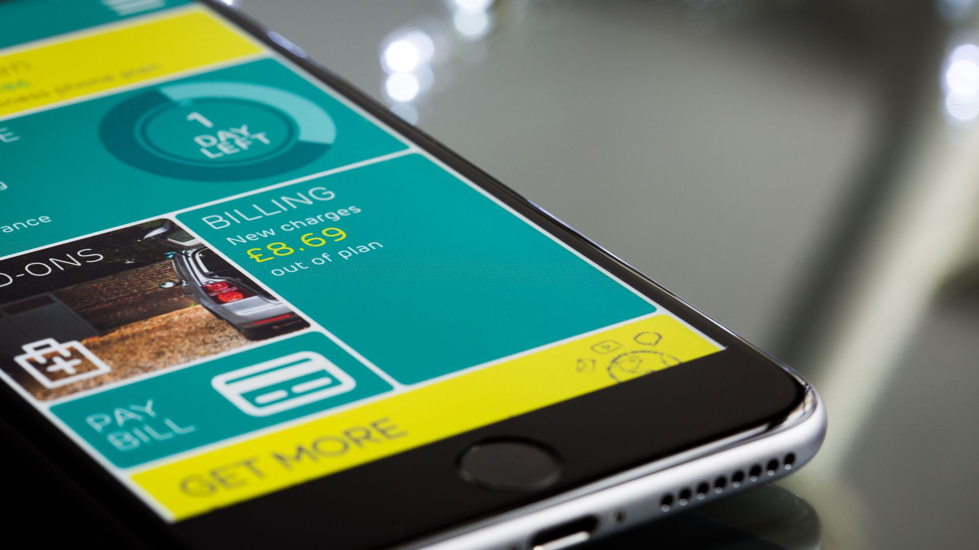 Close-up of a smartphone displaying a billing app interface on a reflective surface.