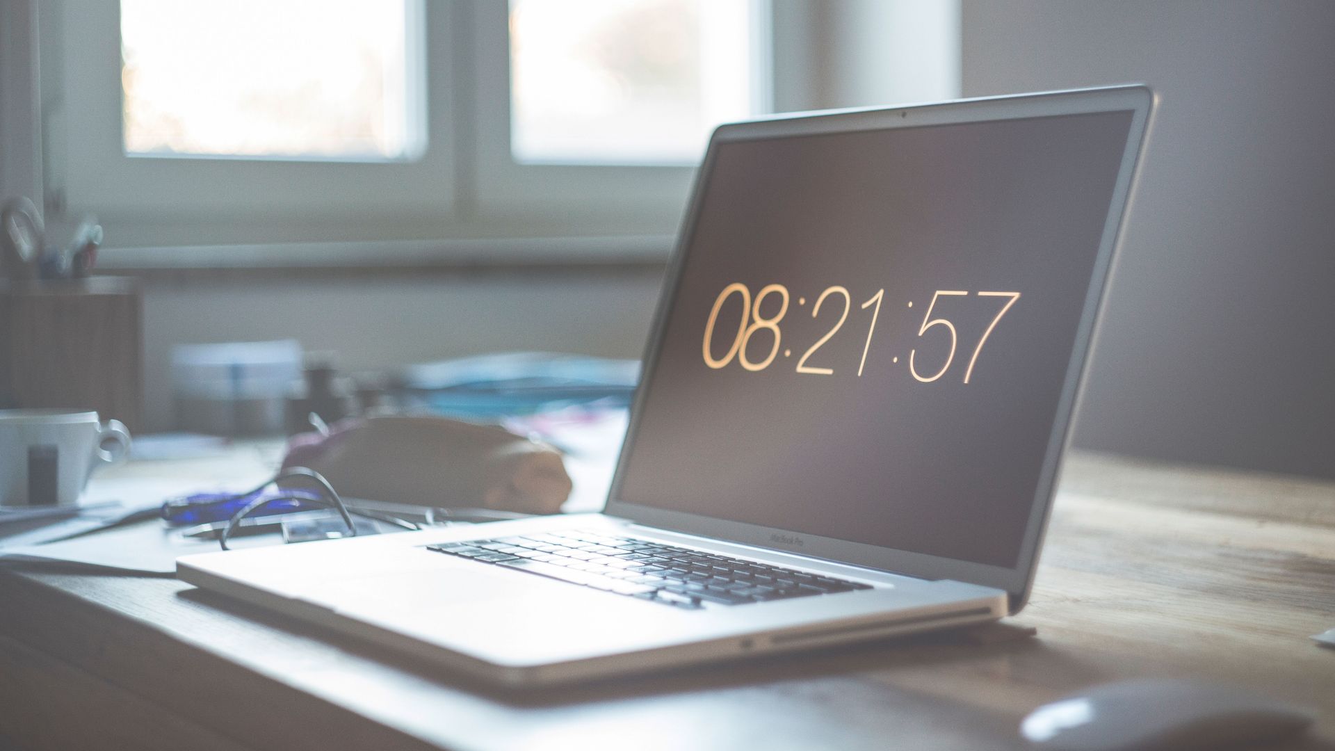 A serene workspace featuring a laptop with digital time display, perfect for productivity and focus.