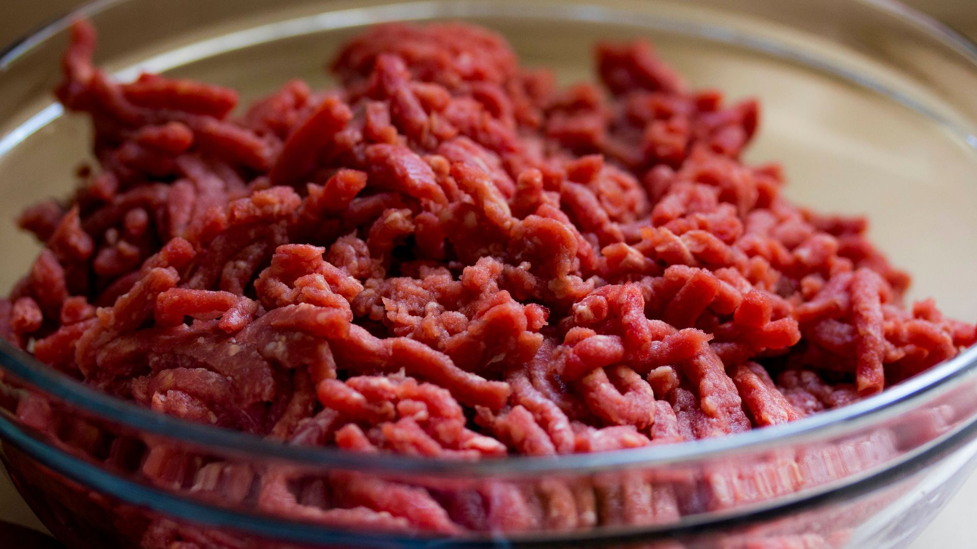 High-quality image of fresh ground beef in a glass bowl, ideal for culinary and food-related themes.