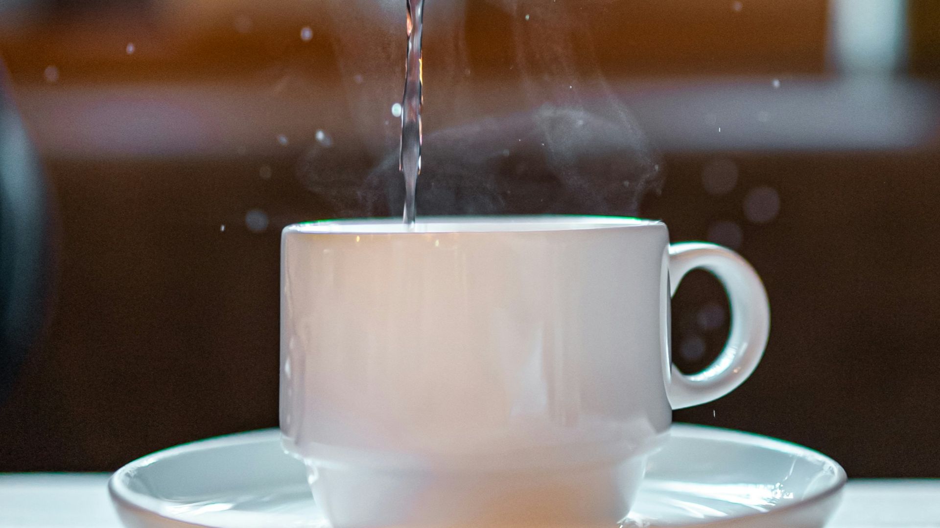 white ceramic teapot pouring water on white ceramic teacup