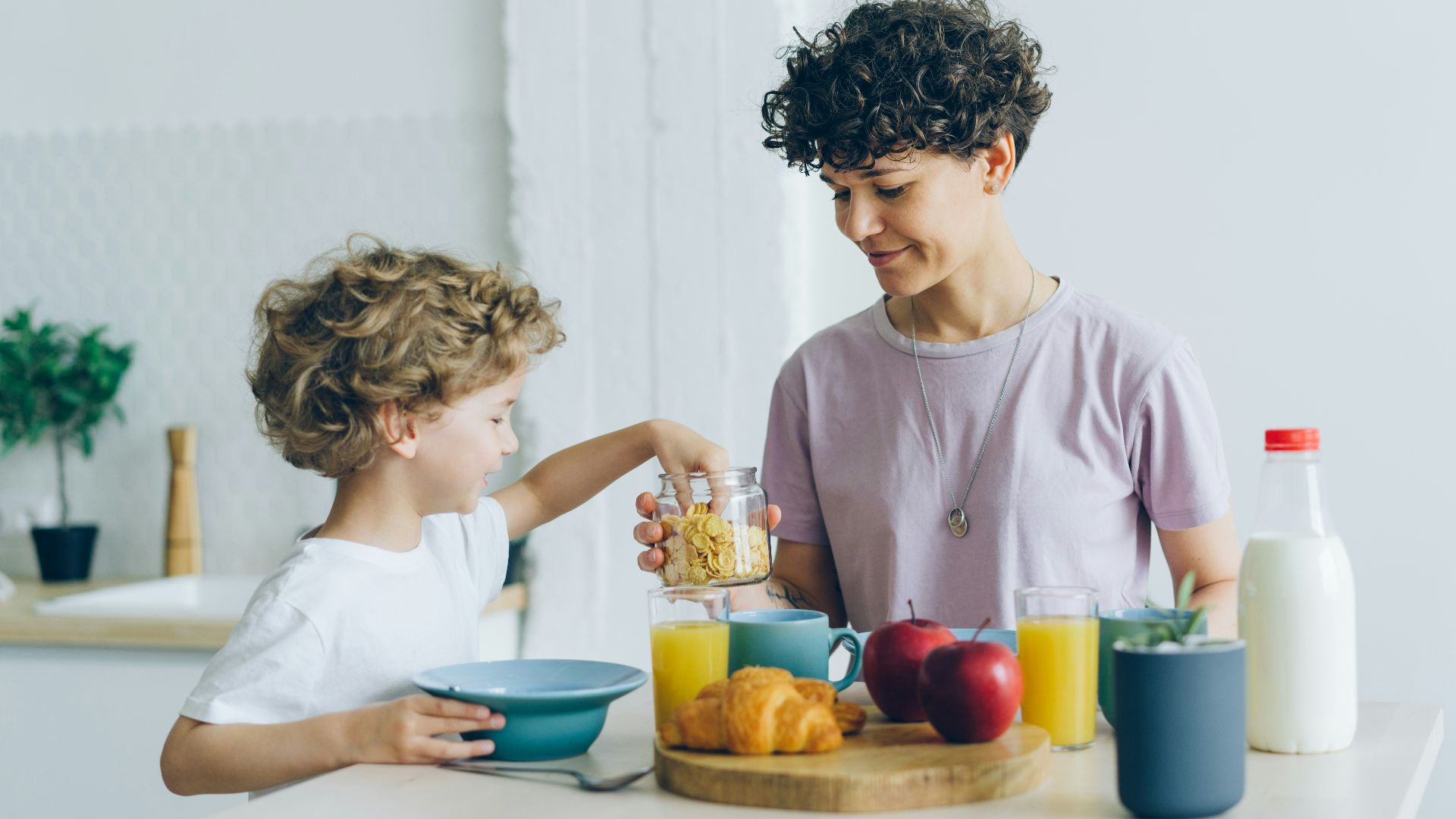 a woman and a child are having breakfast together