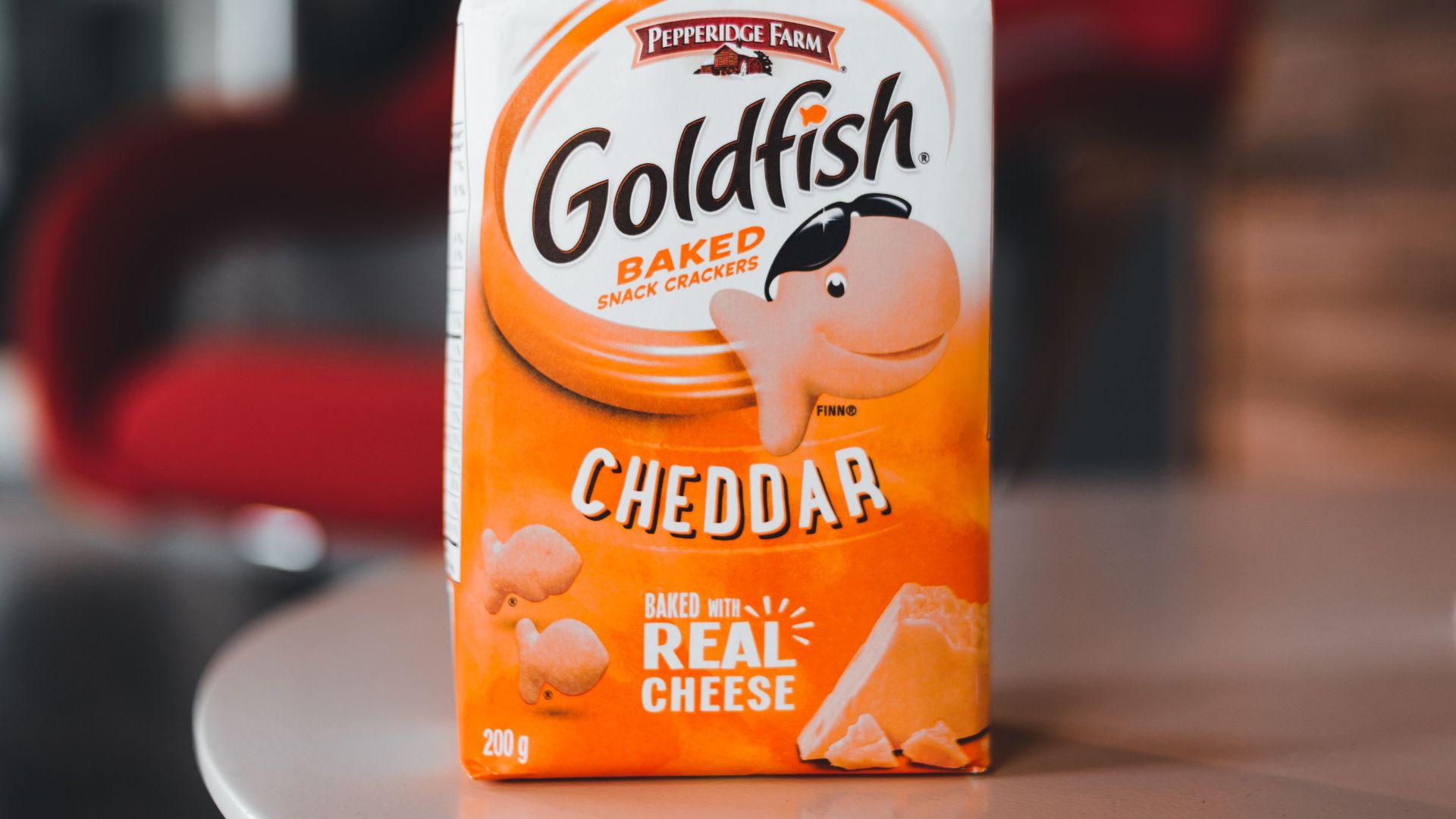 Close-up of a Goldfish Cheddar snack bag on a modern table in an indoor setting.