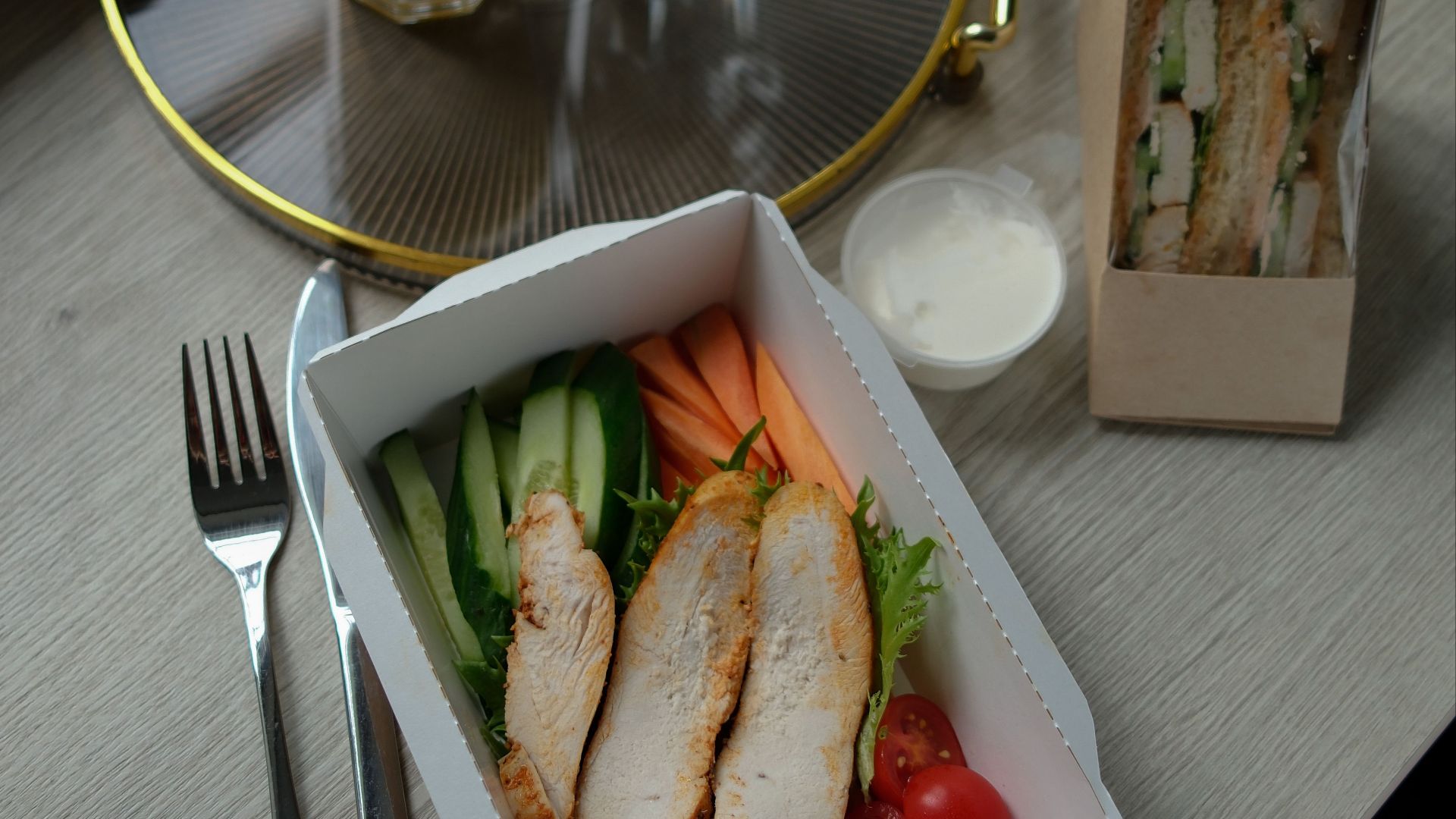 A delicious and balanced breakfast with chicken salad, juice, and sandwiches.
