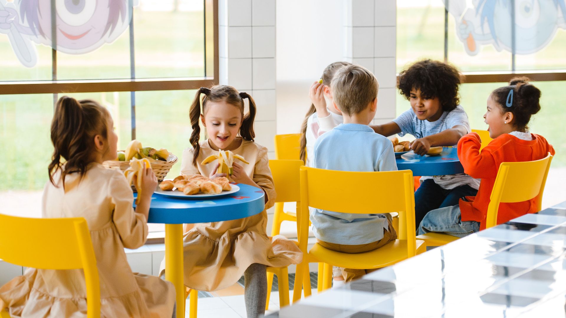 Group of children eating together at a school cafeteria, sharing joy and food.
