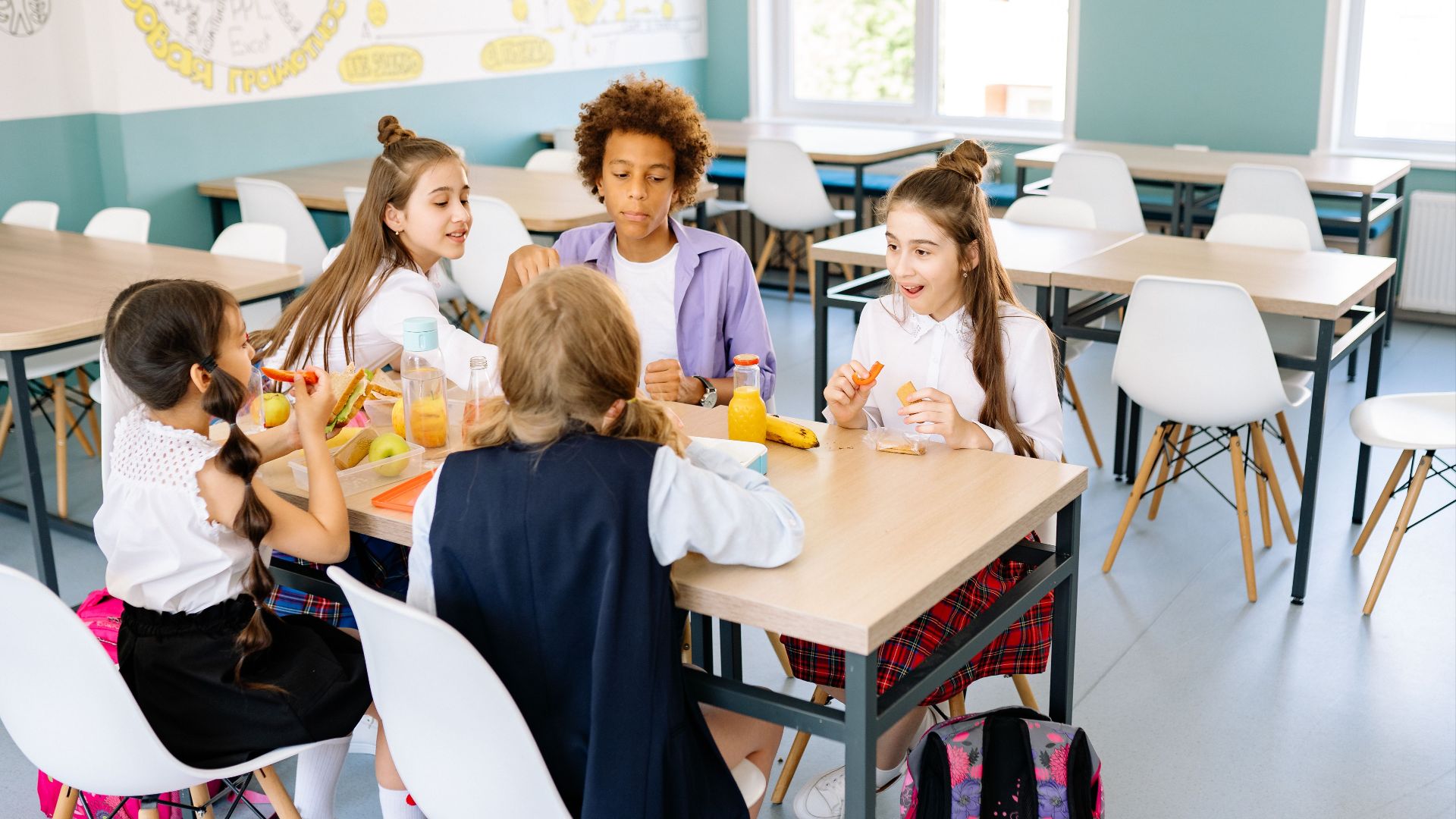 A diverse group of school children enjoying lunch together in a canteen.