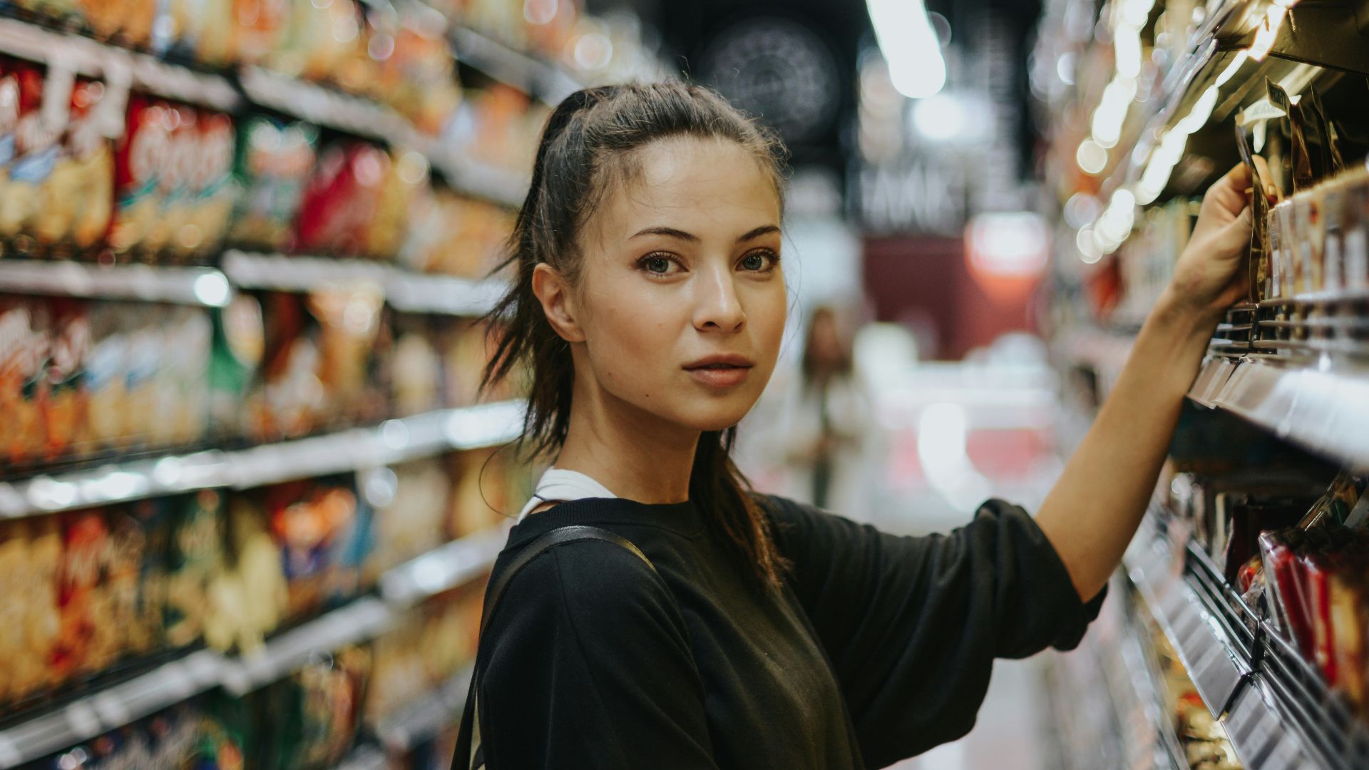 woman shopping in grocery store aisle