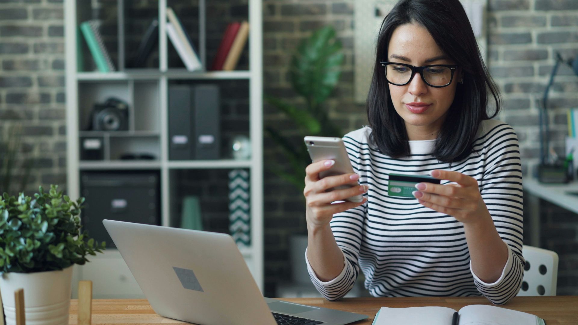 a woman sitting at a table looking at her cell phone
