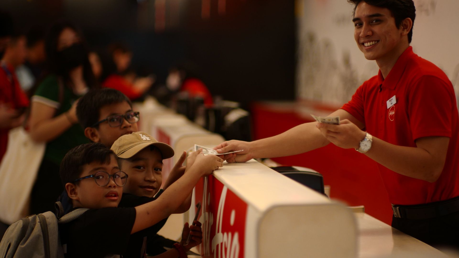Kids purchasing tickets at a service counter in Kuala Lumpur, Malaysia.