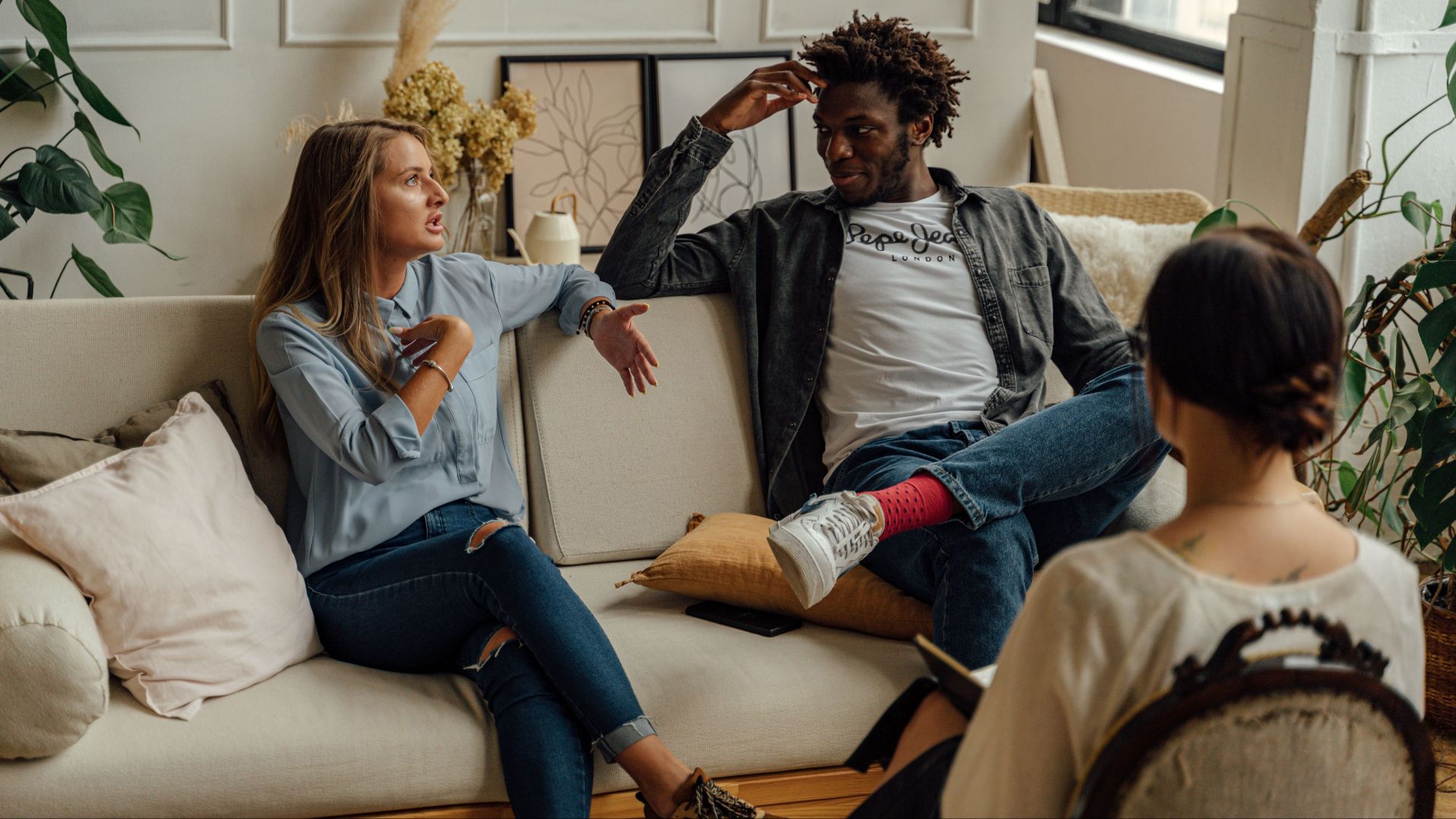 A couple is engaged in a lively conversation during a therapy session with a counselor.