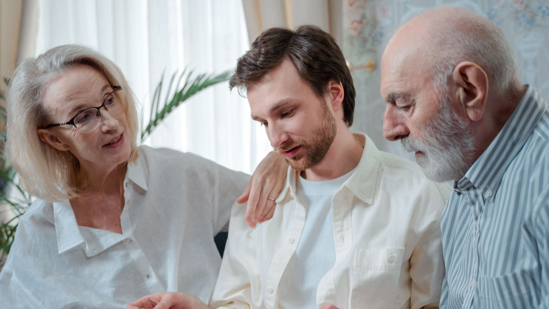 A family looks through a photo album, cherishing memories together indoors.