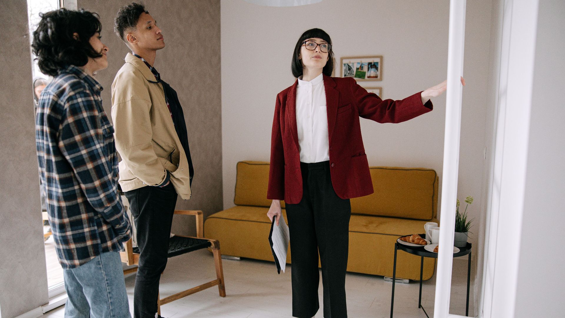 Realtor guiding potential buyers through a stylish apartment viewing.