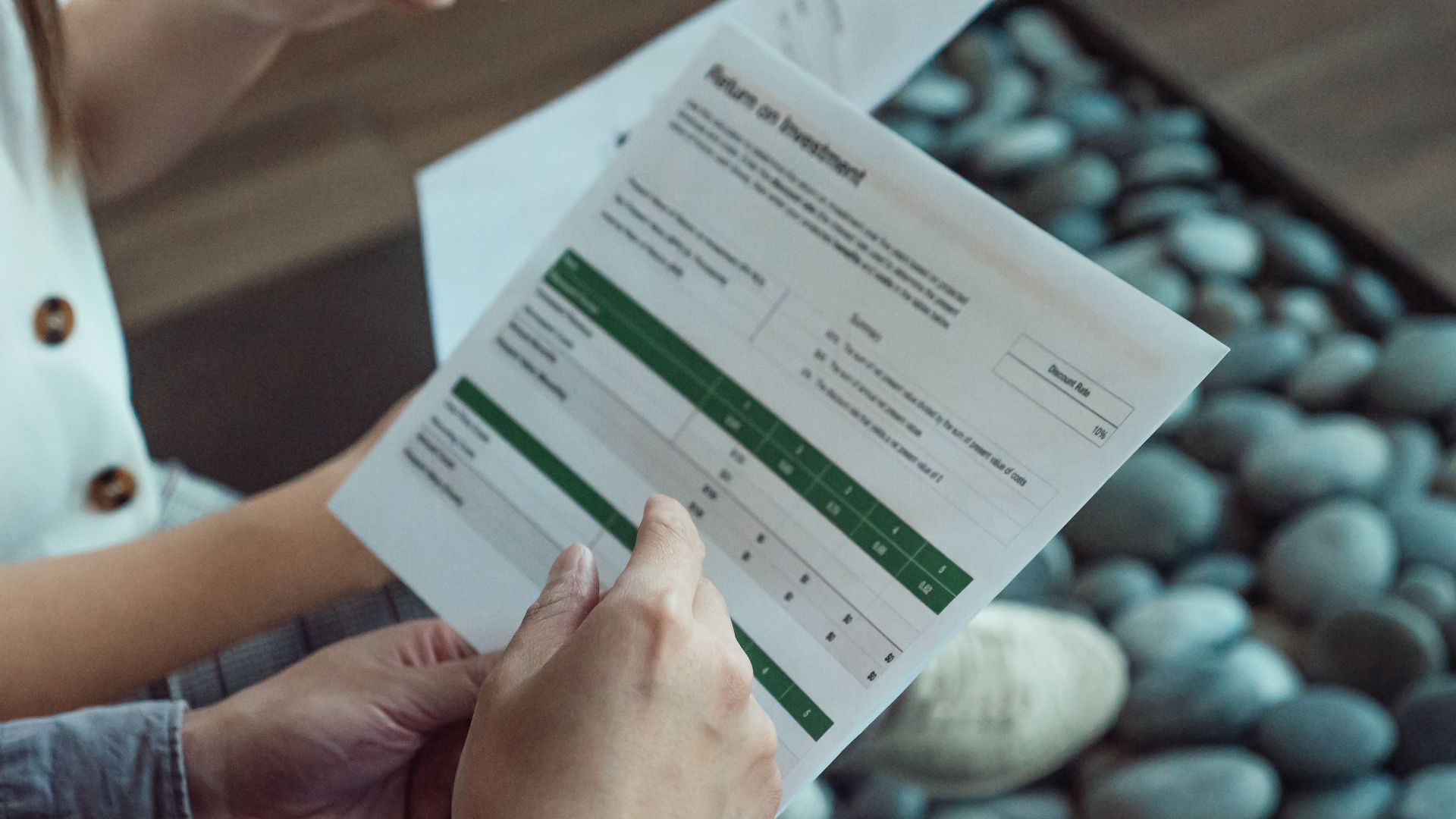 Two people discussing a financial document showing return on investment data.