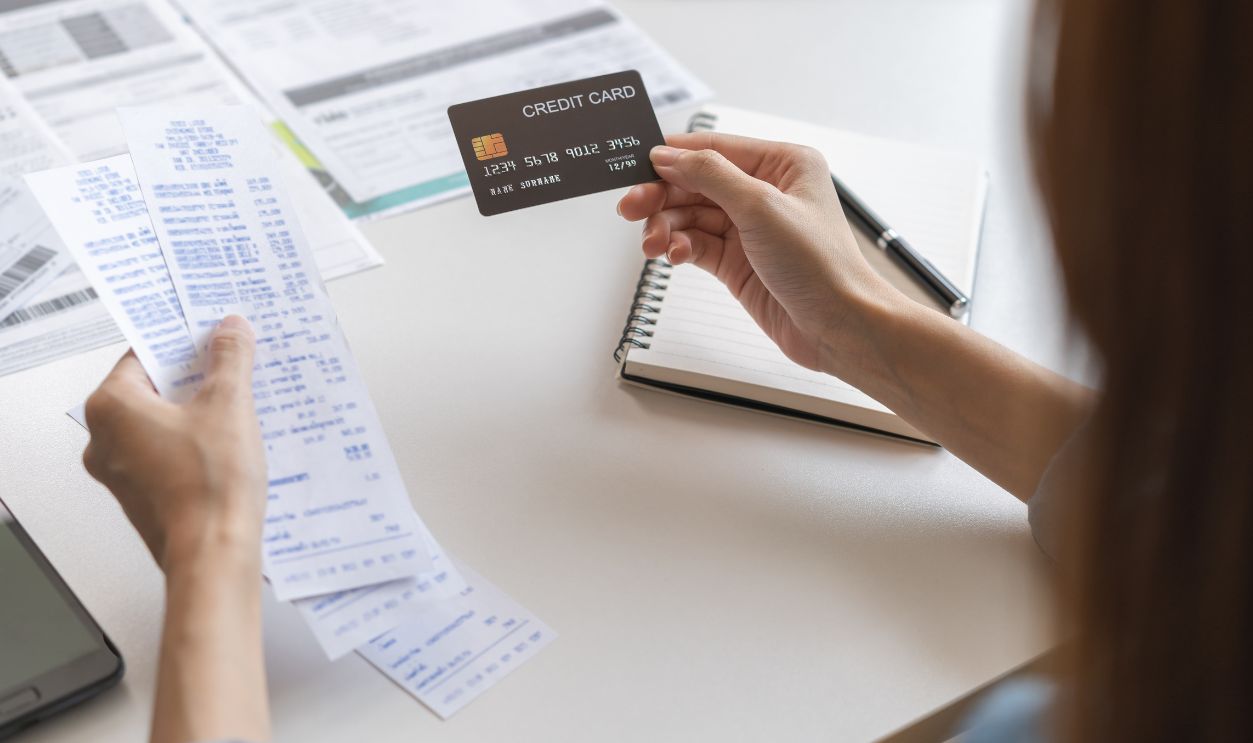 Financial owe, hand of asian woman sitting, holding credit card, stressed by calculate expense from invoice or bill, no money to pay, mortgage or loan. Debt, bankruptcy or bankrupt.