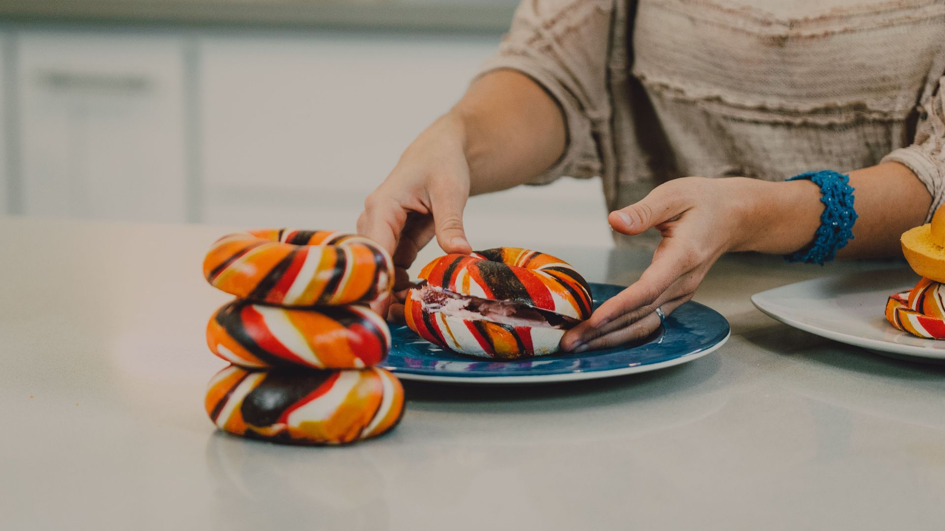 Colorful bagels being arranged on a plate in a contemporary kitchen setting. Perfect for food photography.