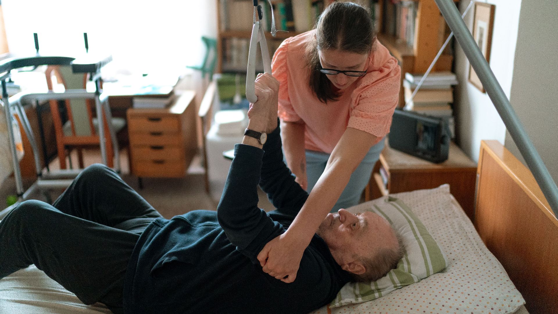 A caregiver assists an elderly man in a home environment, showcasing compassionate home care.