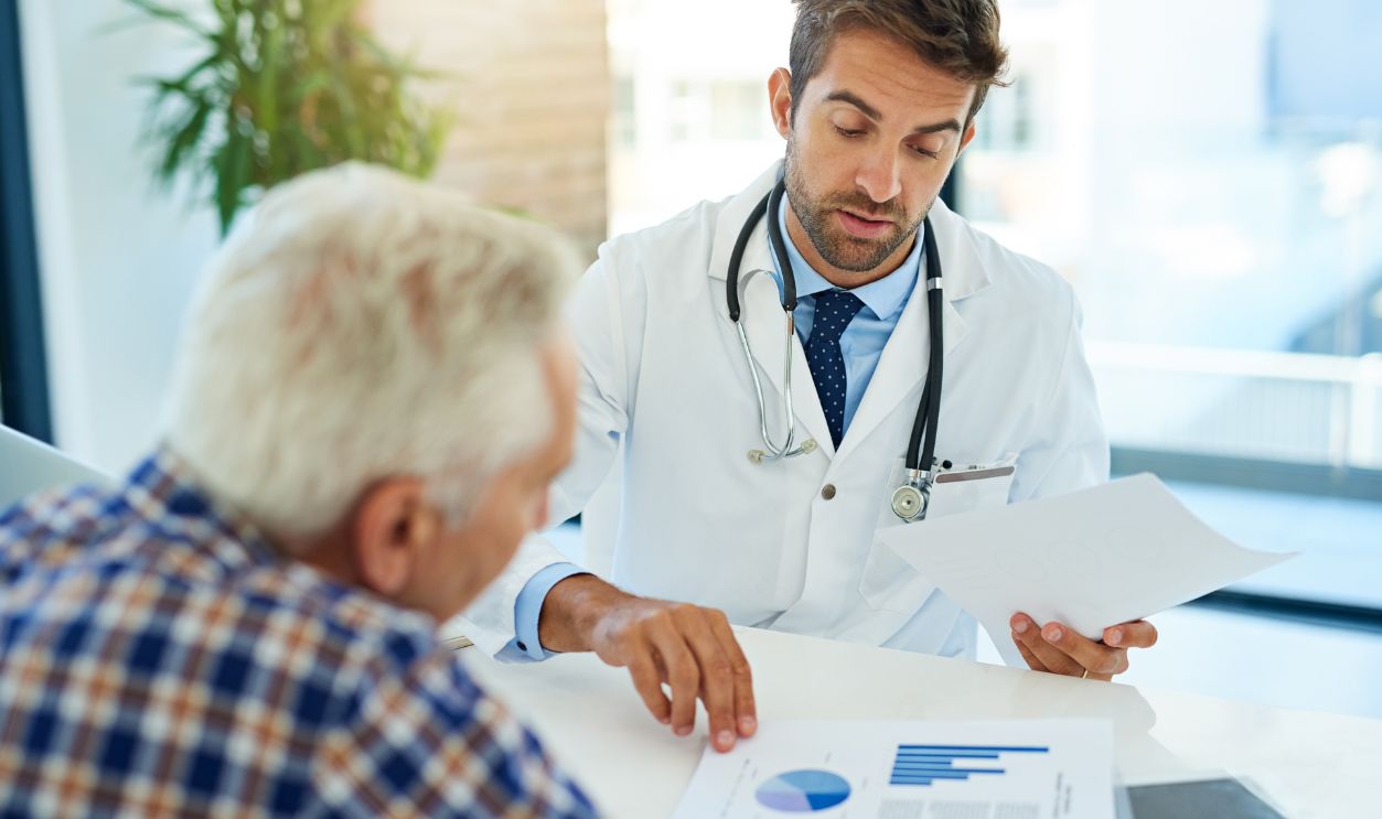 Documents, hospital or medical with doctor and old man in office for consulting appointment. Checkup, insurance or trust with senior patient and medicine professional in clinic for medicare advice