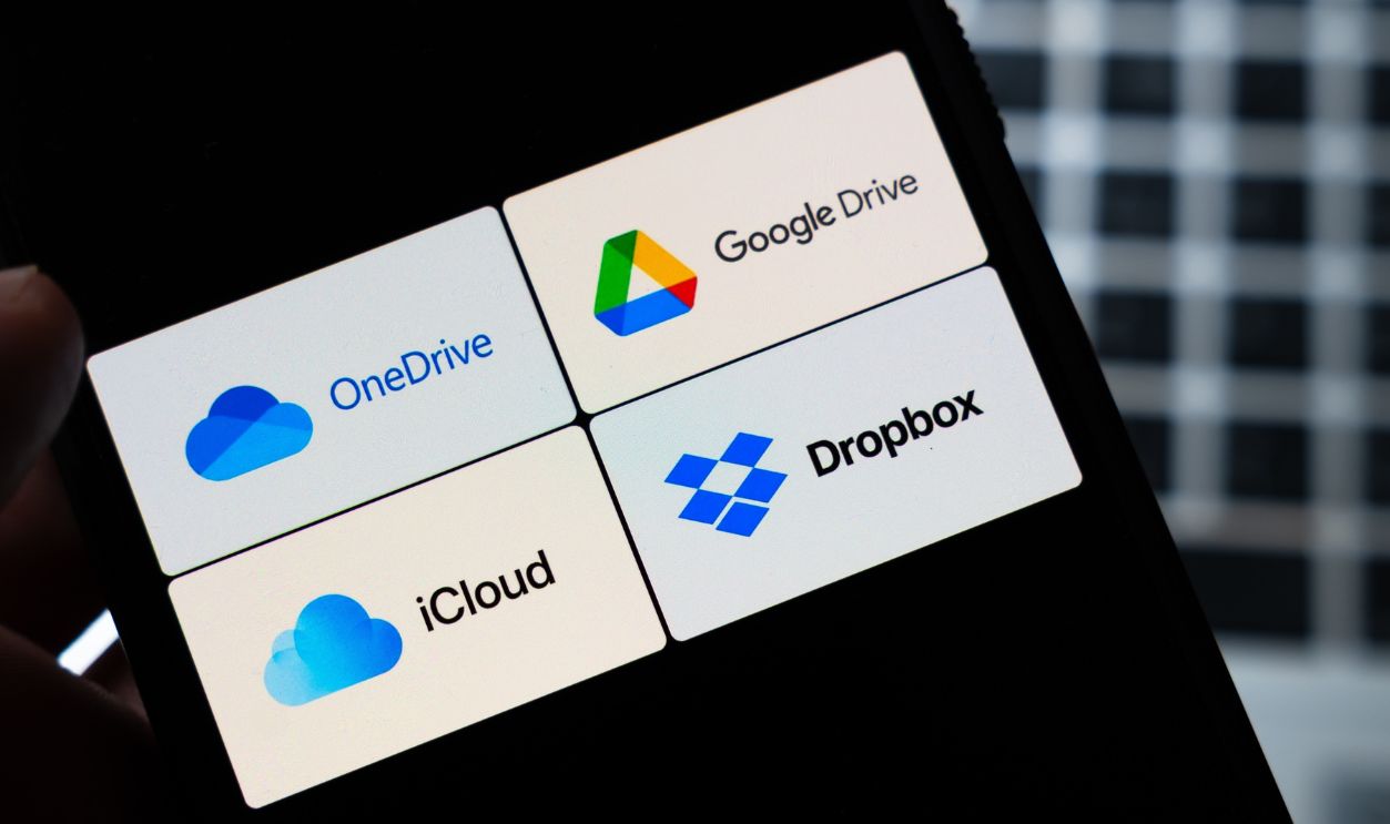 Warsaw, Poland - July 26, 2026: Cloud storage apps OneDrive Google Drive iCloud and Dropbox displayed on smartphone screen held in hand against dark background