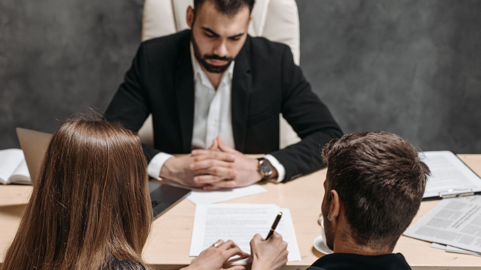 A lawyer discusses legal documents with clients in an office setting.