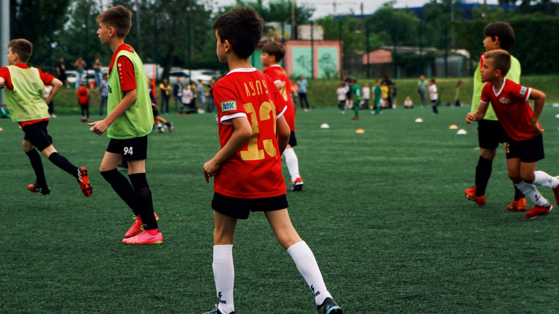 Young kids playing soccer on a green field during the day. Engaged in a fun sporting activity.