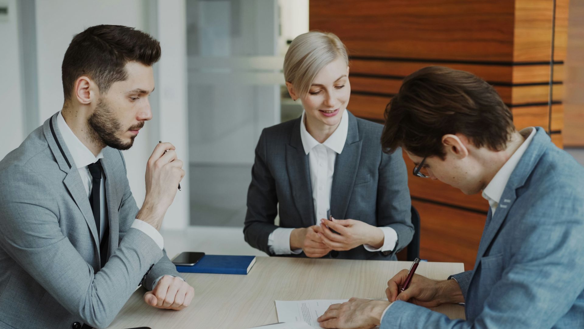 Business people signing a contract at a table