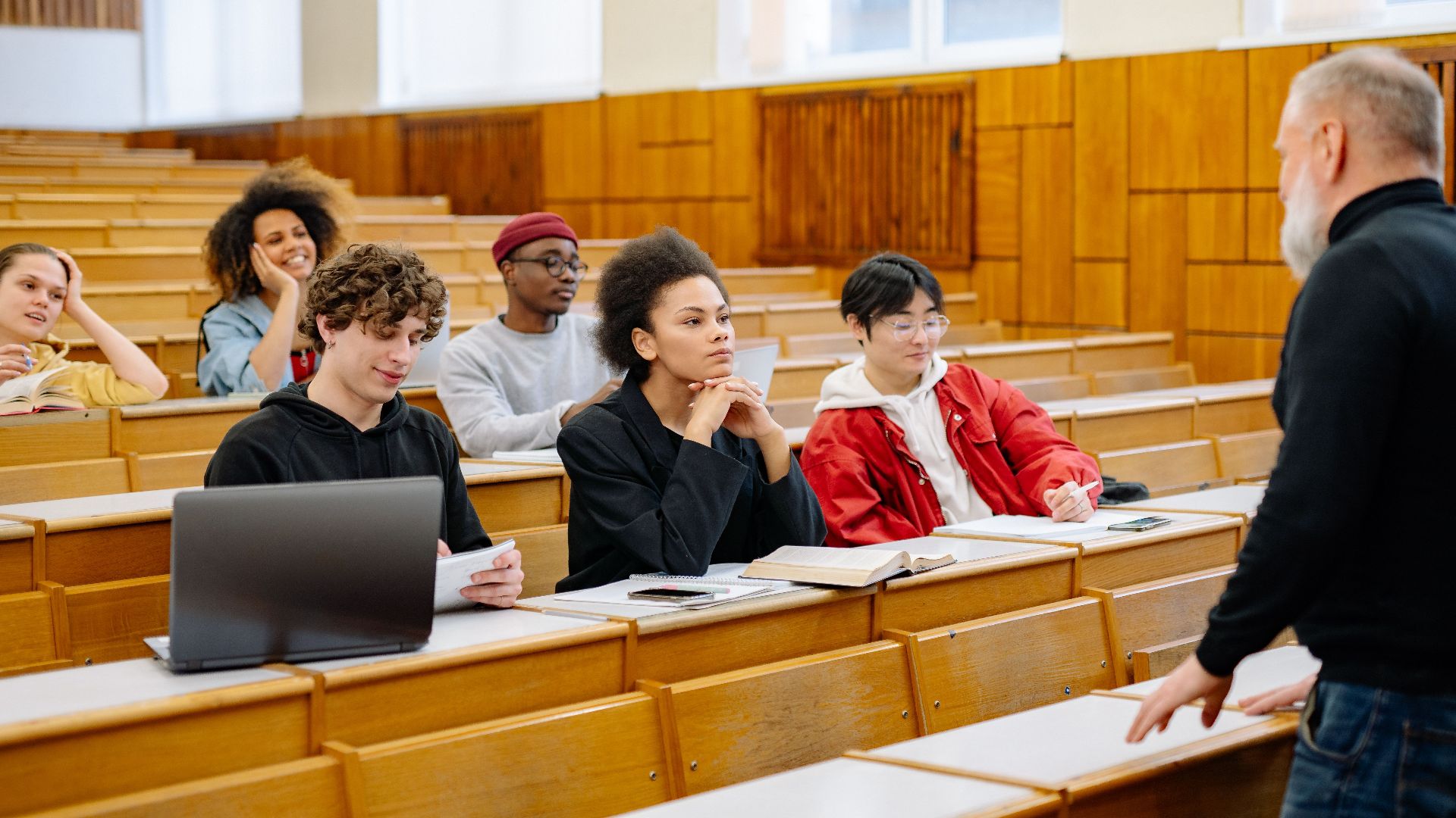 Students from diverse backgrounds engaged in a university lecture setting.