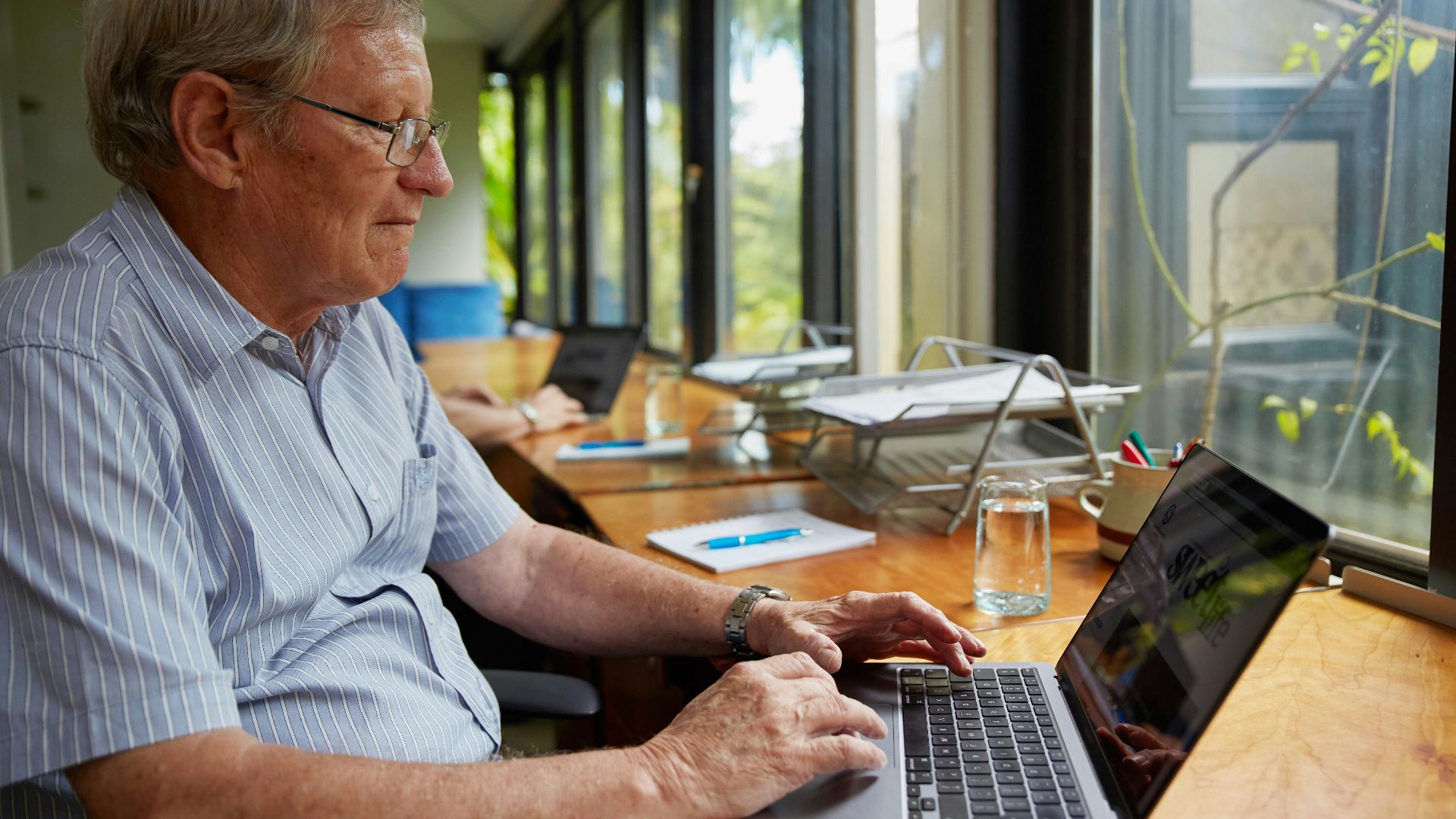 a man sitting at a table using a laptop computer