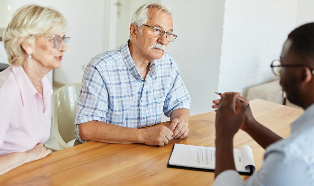 Happy senior old family couple clients make financial insurance estate business deal contract signing, agent lawyer, satisfied mature customers signing contract meeting bank manager agree on investment