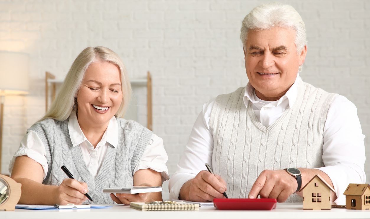 Senior couple calculating utility bills on table at home