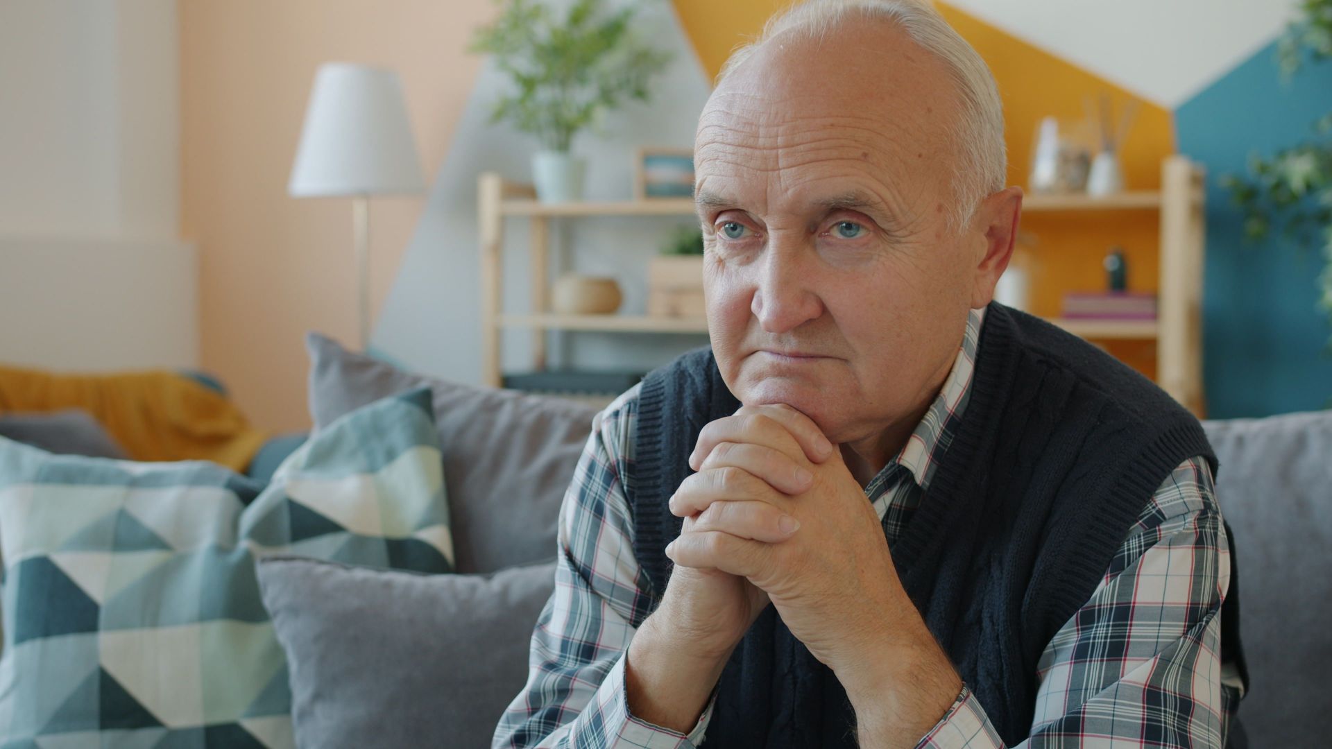 Thoughtful senior man sitting indoors, contemplating life.