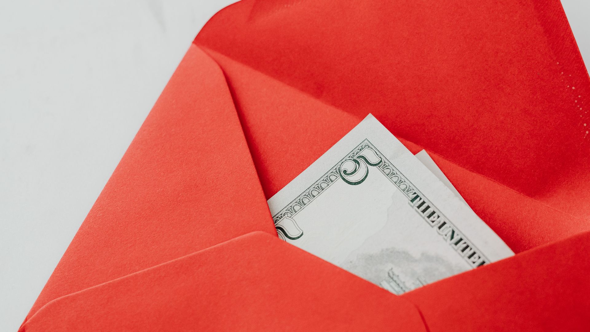 A red envelope containing a five dollar bill, perfect for gifts or special occasions.