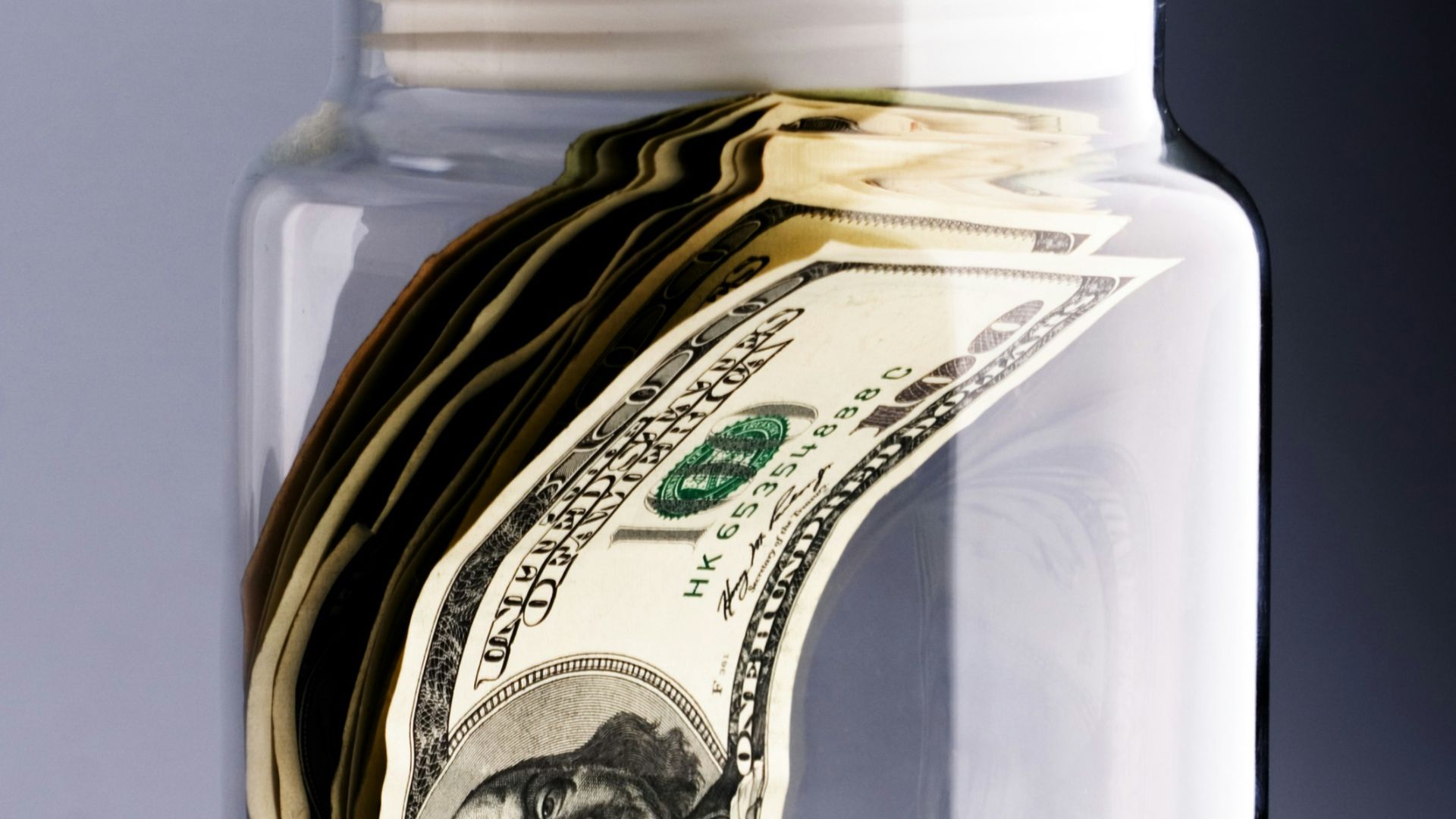A jar filled with money sitting on top of a table