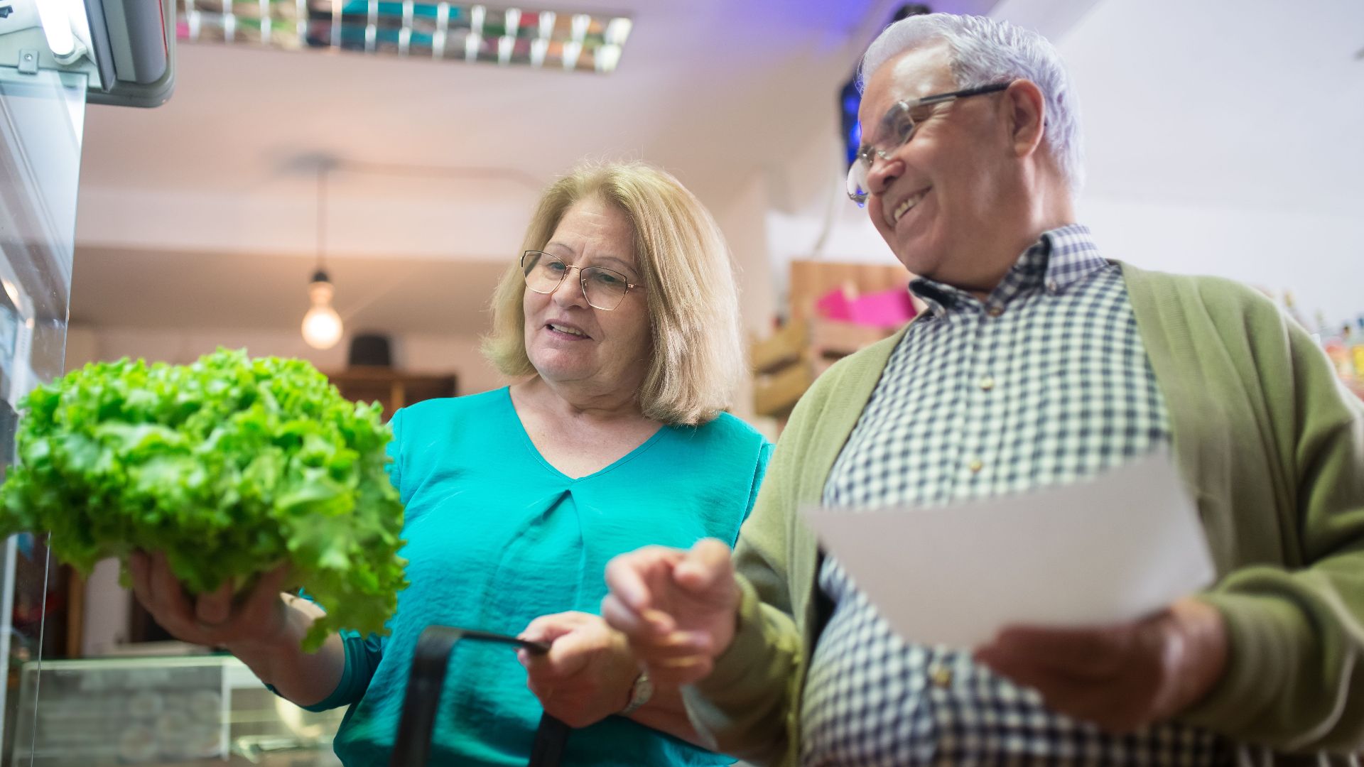 Happy senior couple shopping for fresh vegetables together, enjoying a day out.