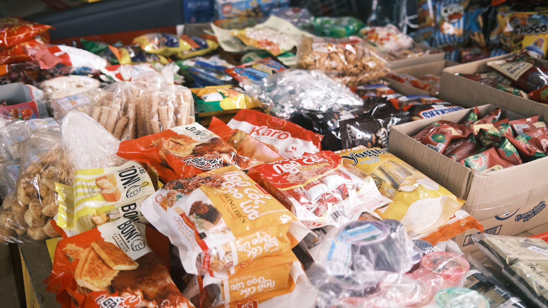 Vibrant array of assorted packaged snacks and candies displayed indoors, perfect for a snack shop or market.