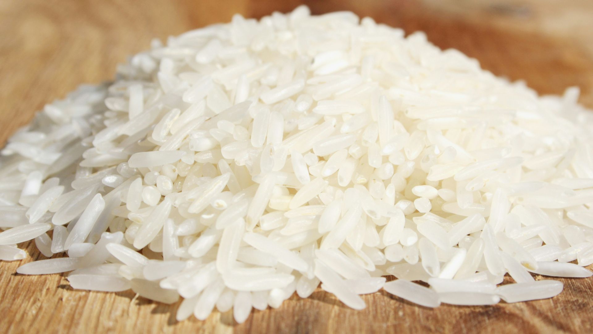 A pile of rice sitting on top of a wooden cutting board