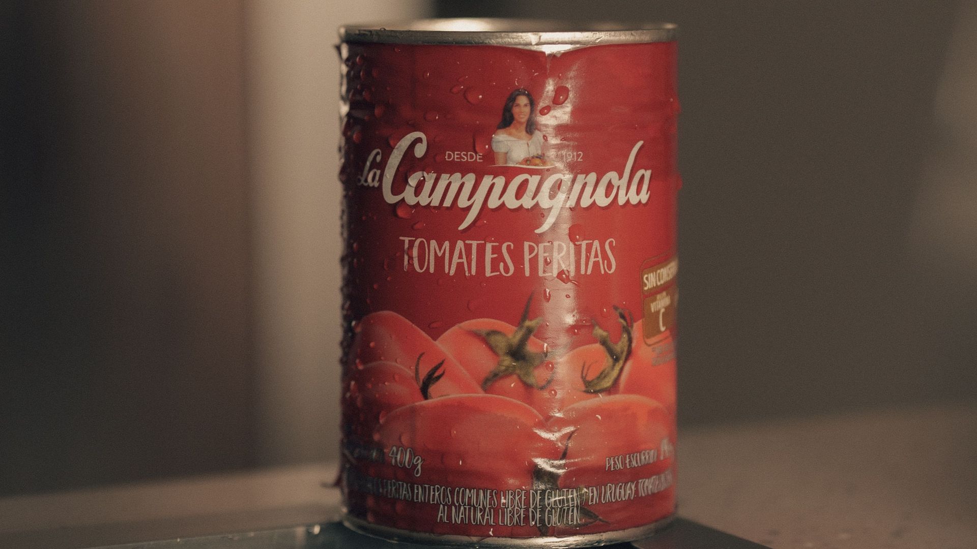 Close-up of a red tomato can on a kitchen sink in soft focus.