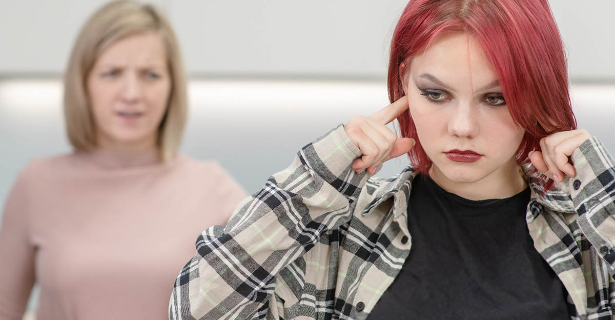 Angry mother scolds her teen daughter at home. Girl plugged her ears and ignores her mother. Family relationships concept
