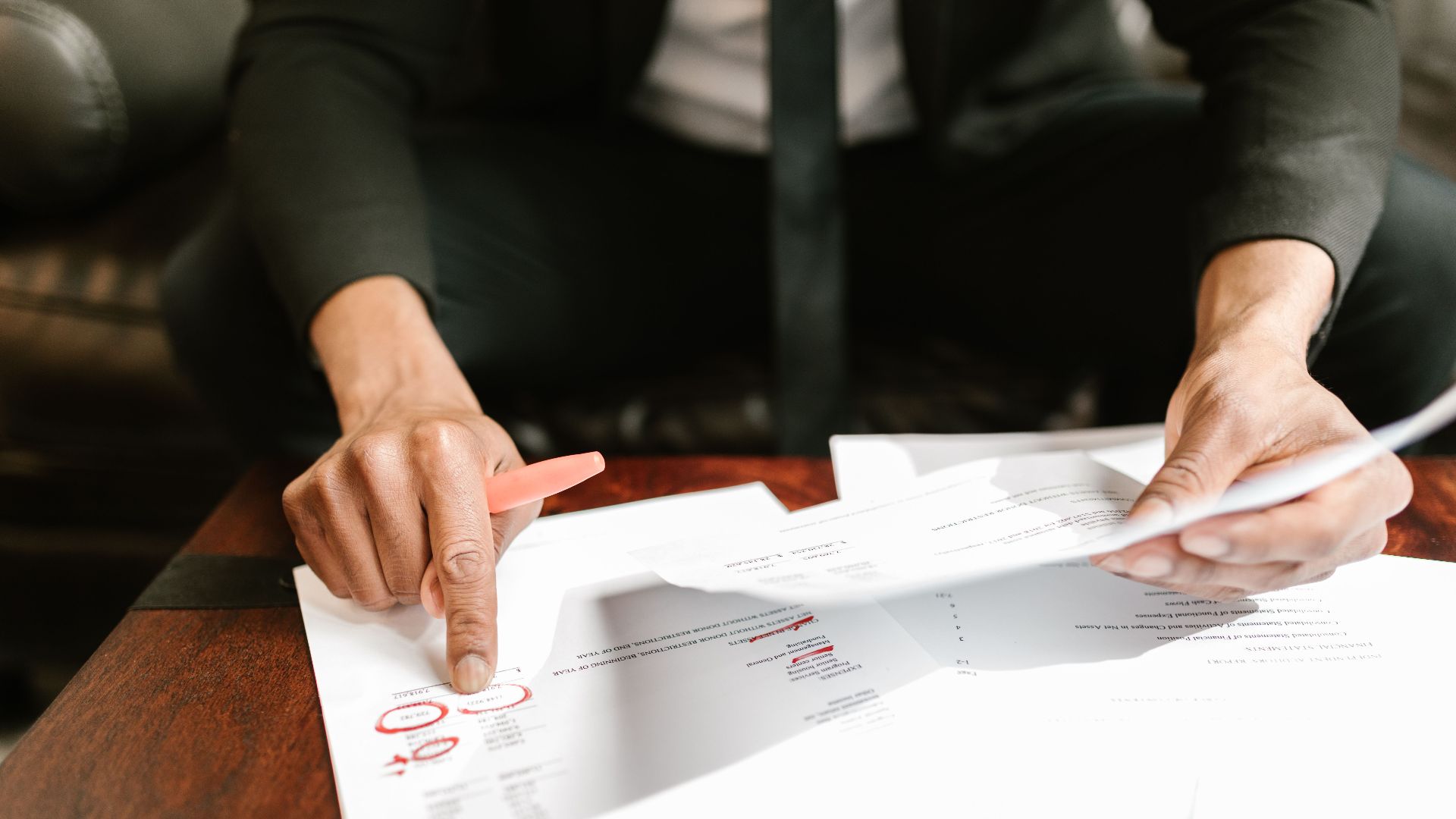 A businessman analyzing financial documents with important data and figures on a desk, ideal for business analytics and accounting themes.