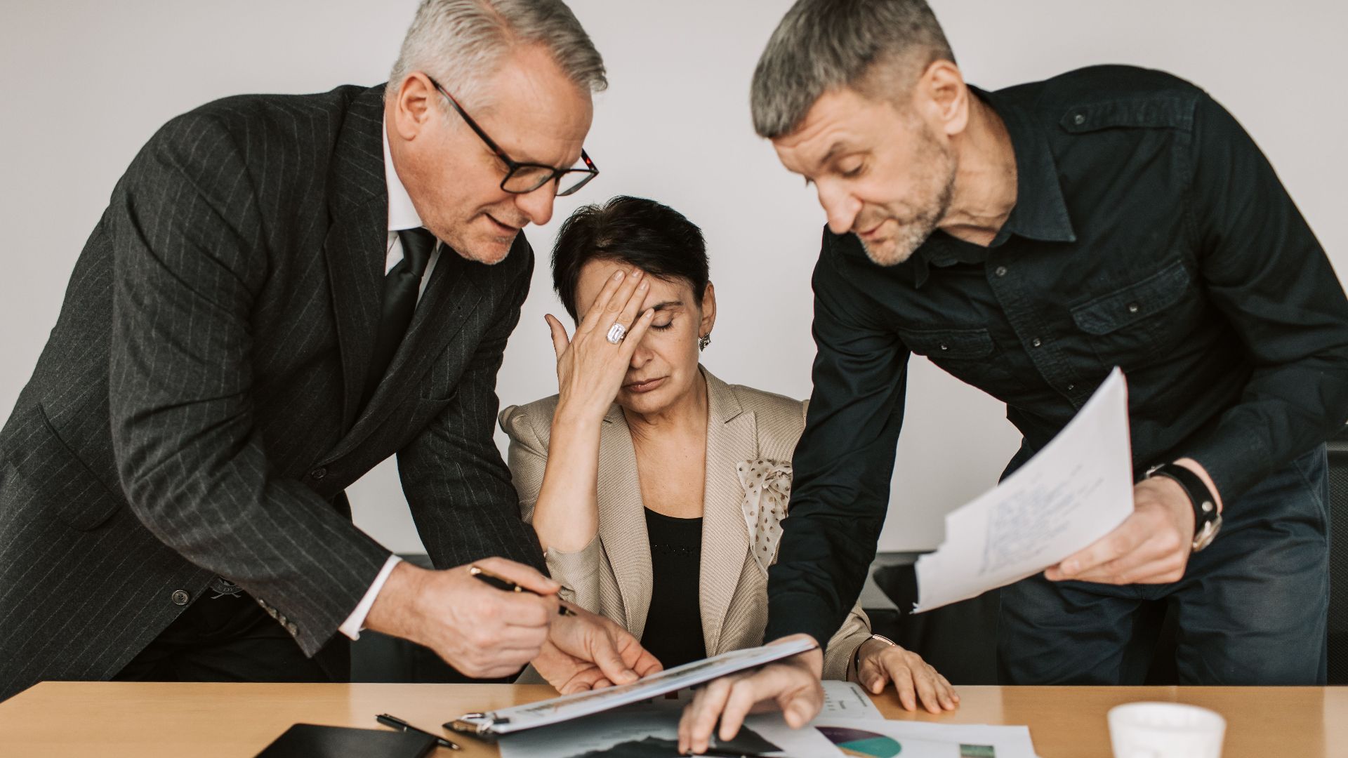 A professional team in a tense business meeting discussing financial documents.