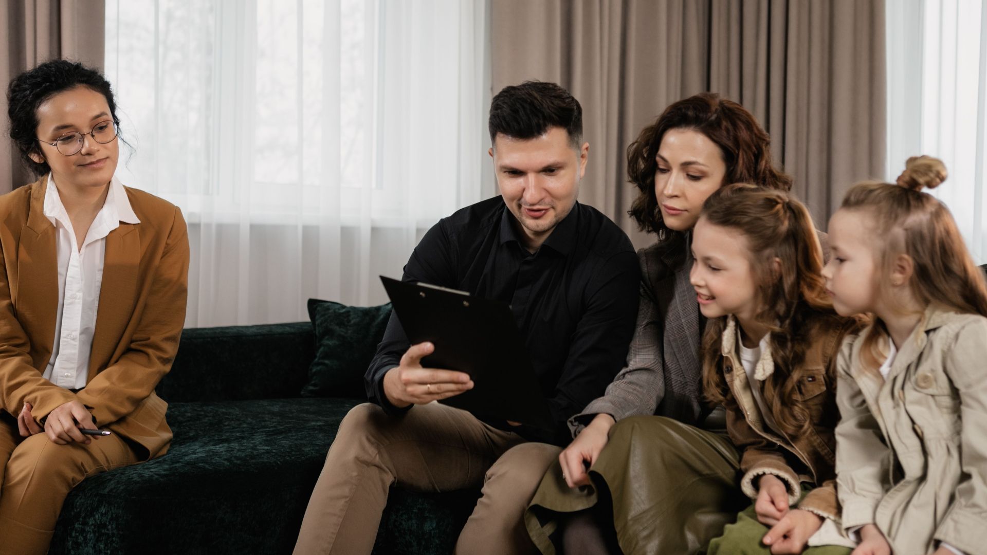 A family receiving advice from a professional advisor indoors, focused on financial planning.